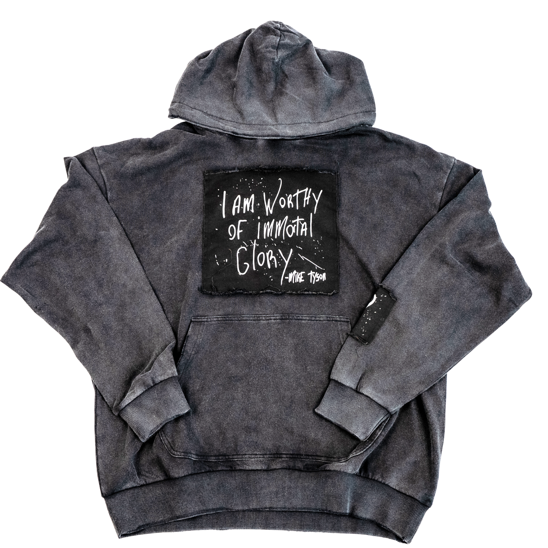 Black distressed hoodie with front pockets. A large black patch on the chest highlights Mike Tyson's handwriting that states "I am Worthy of Immortal Glory." A small patch on the left arm displays the Tyson "hook" logo. A medium patch on the back bottom right displays the full Tyson logo.