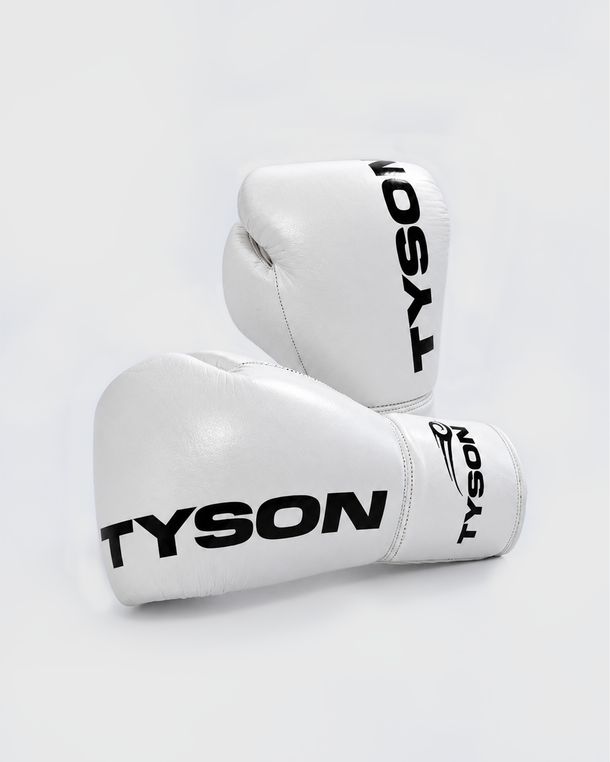 White boxing gloves. Black text saying "Tyson" runs vertically towards the fingers on the back of the gloves, while the Tyson Pro logo is on the wrist. The palm side of the glove features laces.