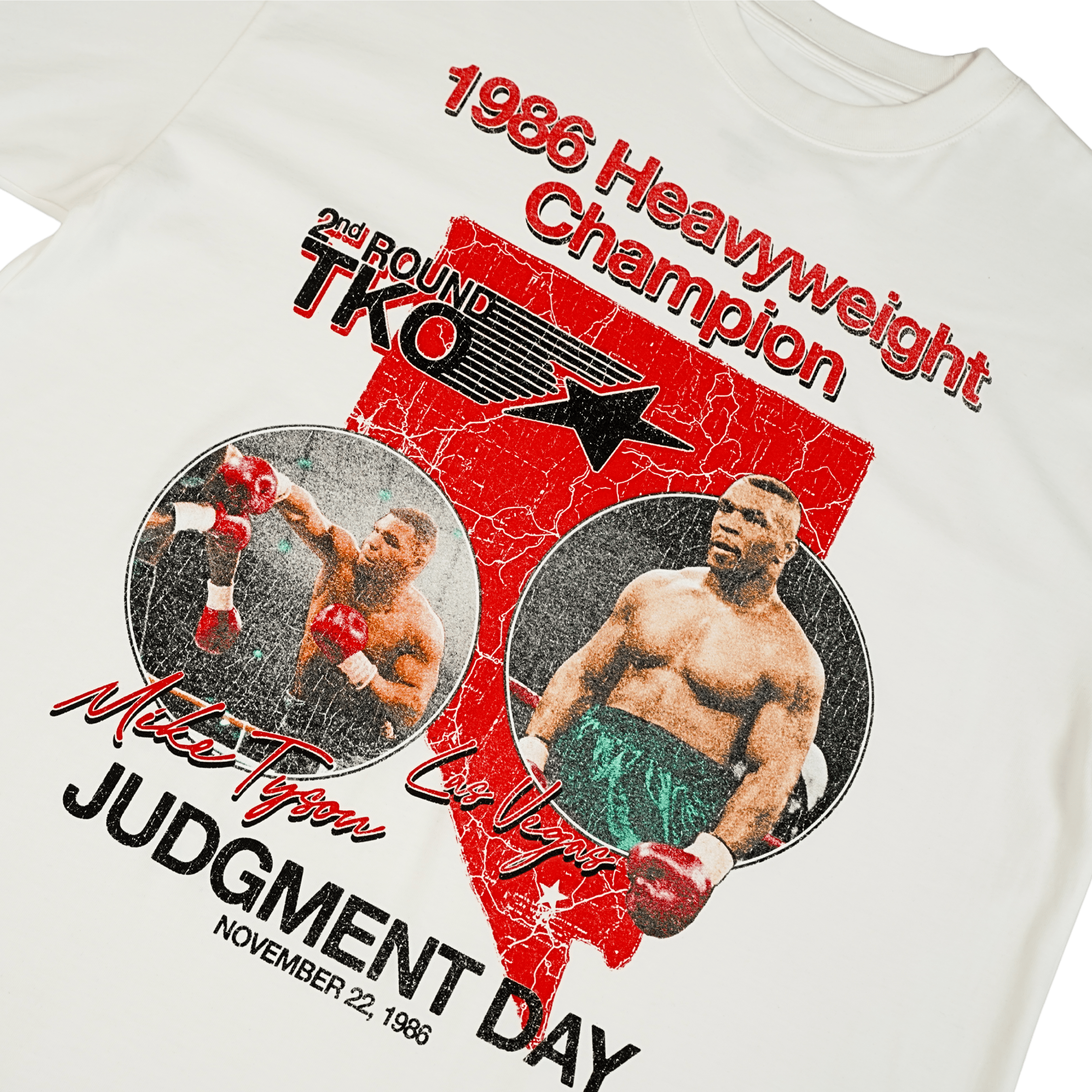 White T-shirt with the state of Nevada in red in the background, with two images of Mike in the foreground. 1986 Heavyweight Champion is written across the top and Judgement Day November 22, 1986 is at the bottom. Other text surrounding the images include 2nd round TKO, Mike Tyson, and Las Vegas.