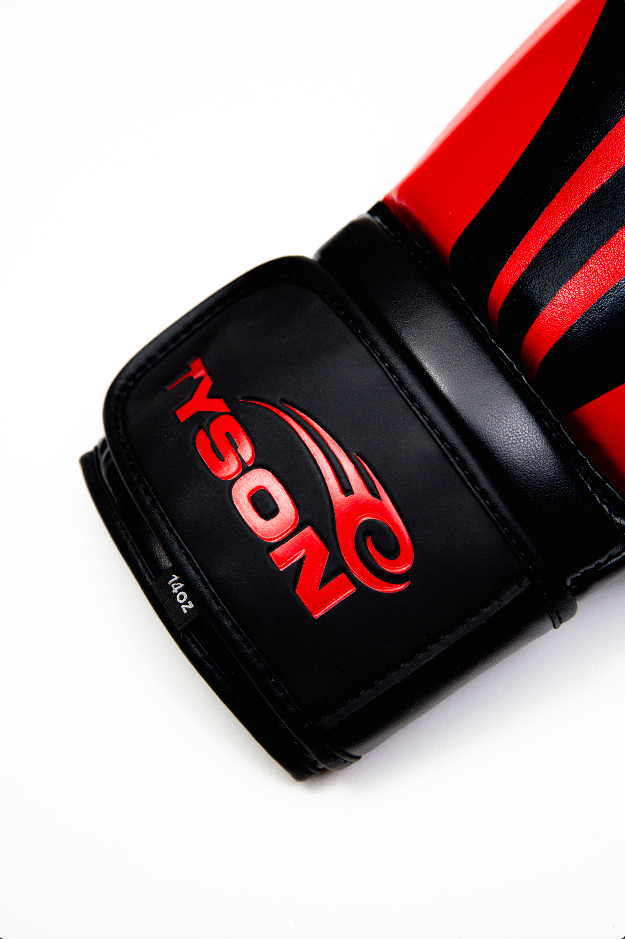 Black boxing gloves with red accents. The Tyson half tribal logo is featured on the back of the gloves and the Tyson Pro logo is on the wrist strap. The palm area has mesh.