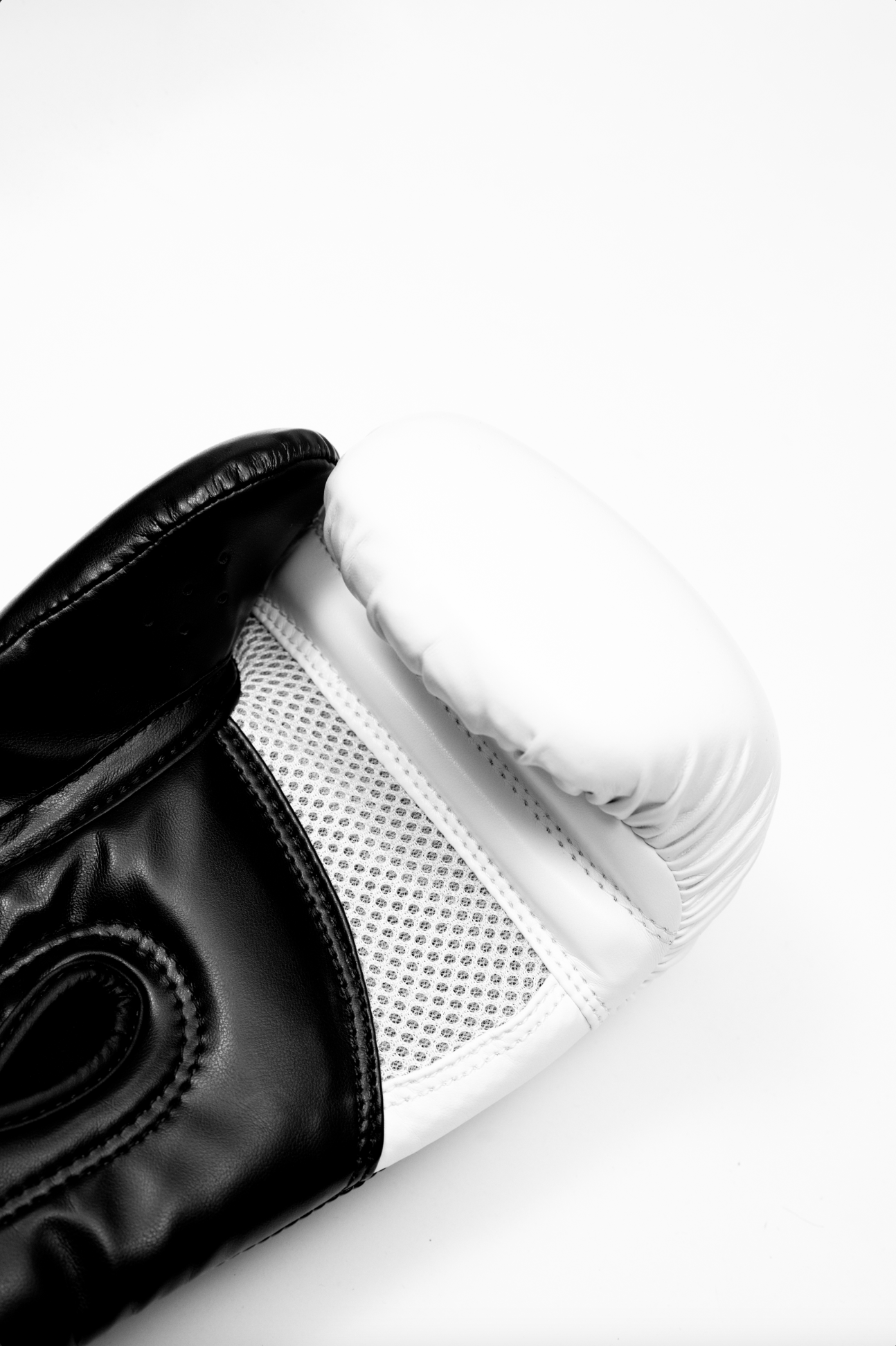 Black boxing gloves with white accents. The Tyson half tribal logo is featured on the back of the gloves and the Tyson Pro logo is on the wrist strap. The palm area has mesh.