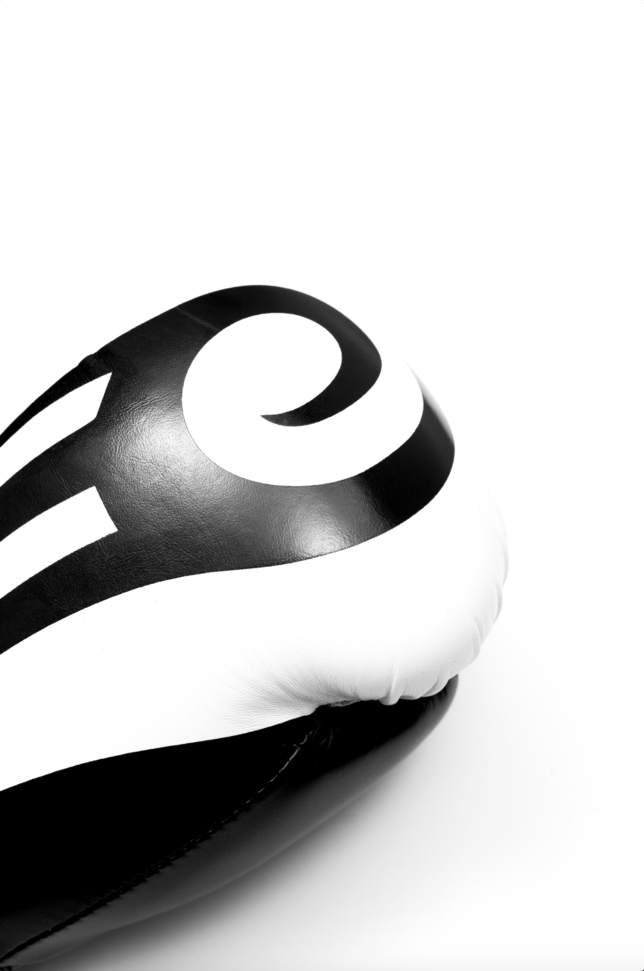 Black boxing gloves with white accents. The Tyson half tribal logo is featured on the back of the gloves and the Tyson Pro logo is on the wrist strap. The palm area has mesh.