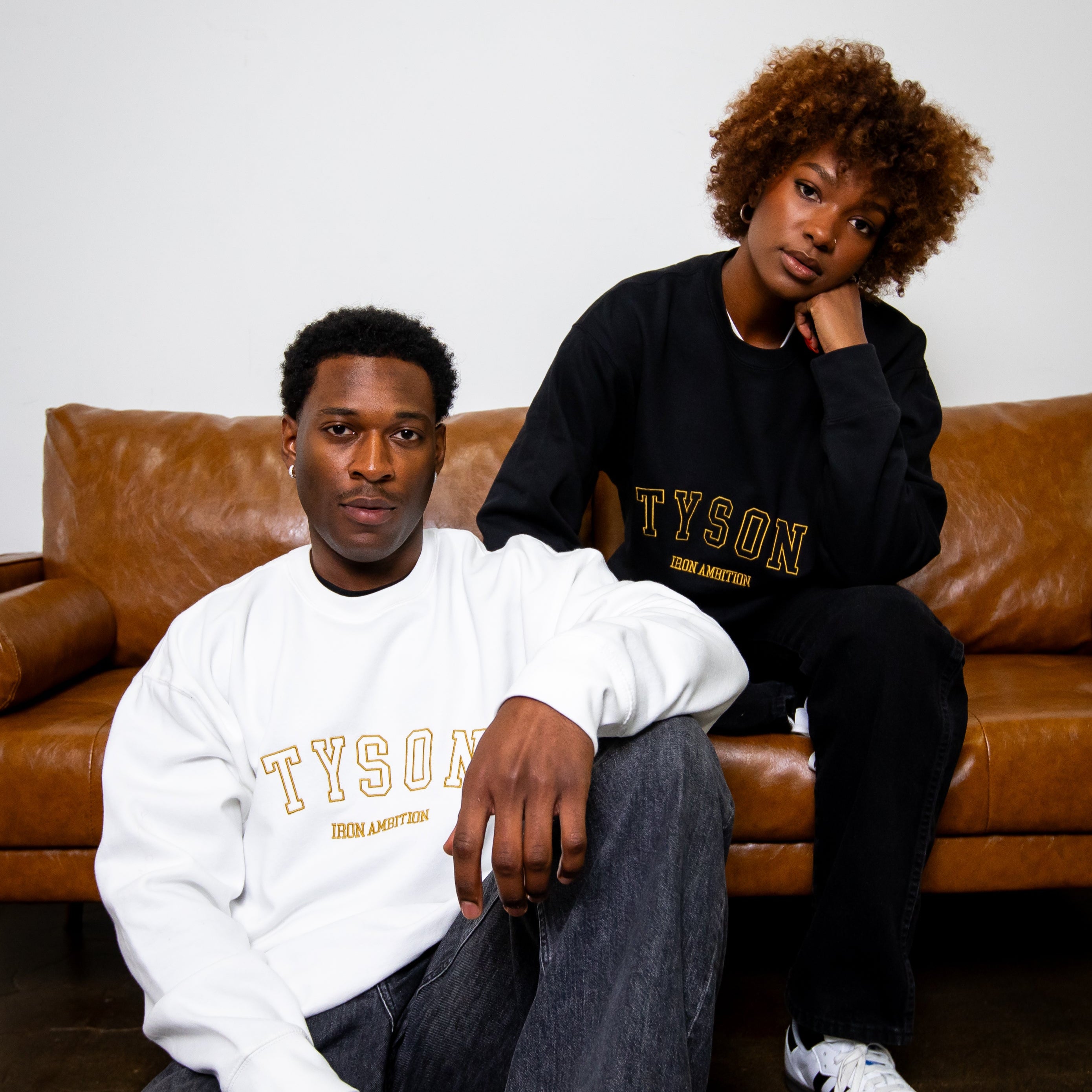 Male and female models wearing the Iron Ambition crewneck sweatshirt.
