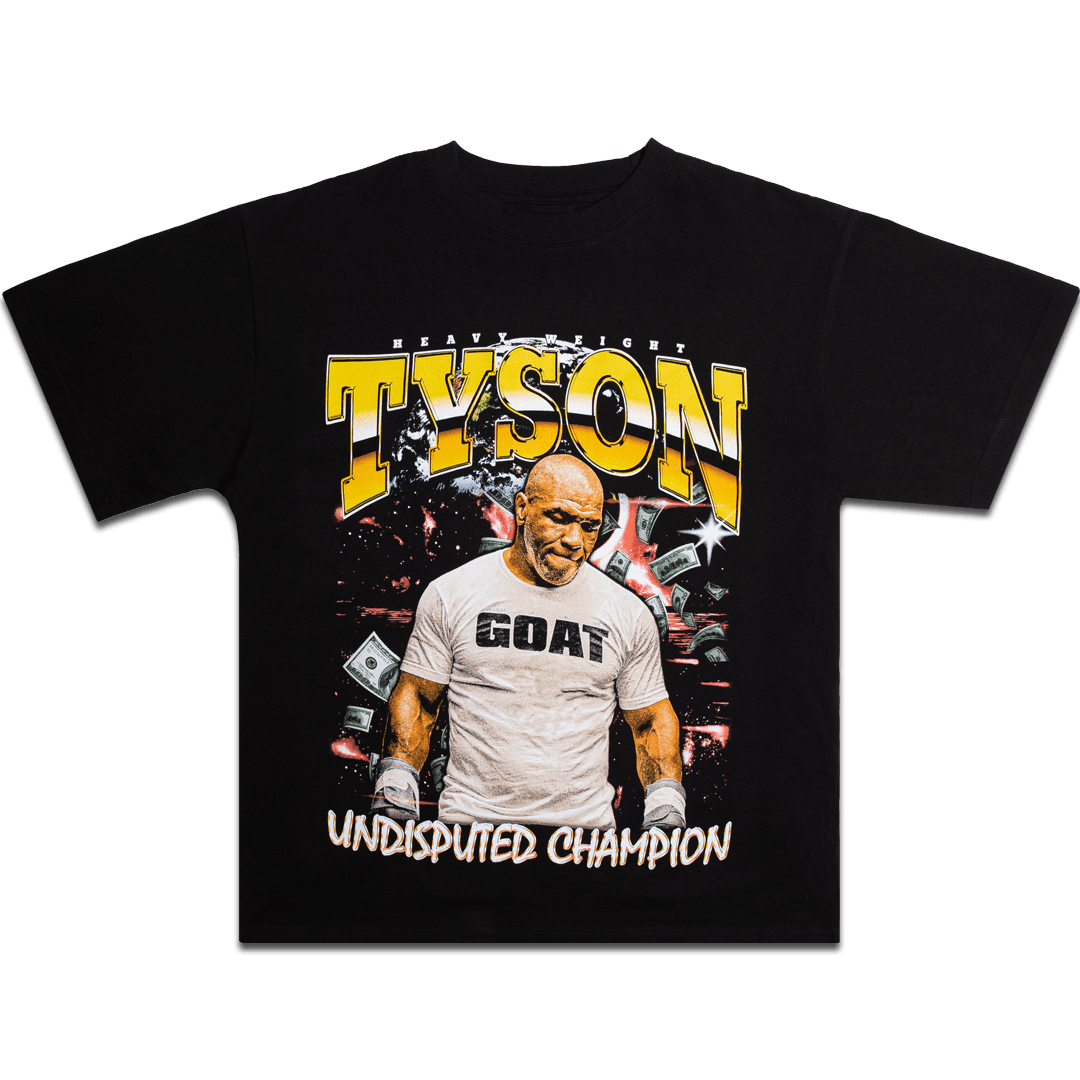 Black T-Shirt with an image of Mike looking down wearing a white shirt with the word GOAT written across the chest. There are hundred dollar bills floating around in the background. Text across the top says "Heavy Weight. Tyson" and the bottom says "Undisputed Champion."