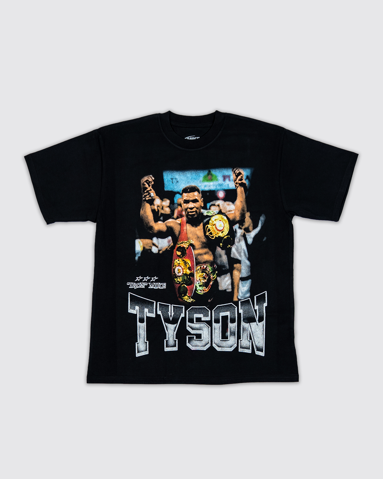Front design: Black T-shirt with image of Mike Tyson with his belts. "Tyson" text runs along the bottom, with a smaller "Iron Mike" text on the left side. 