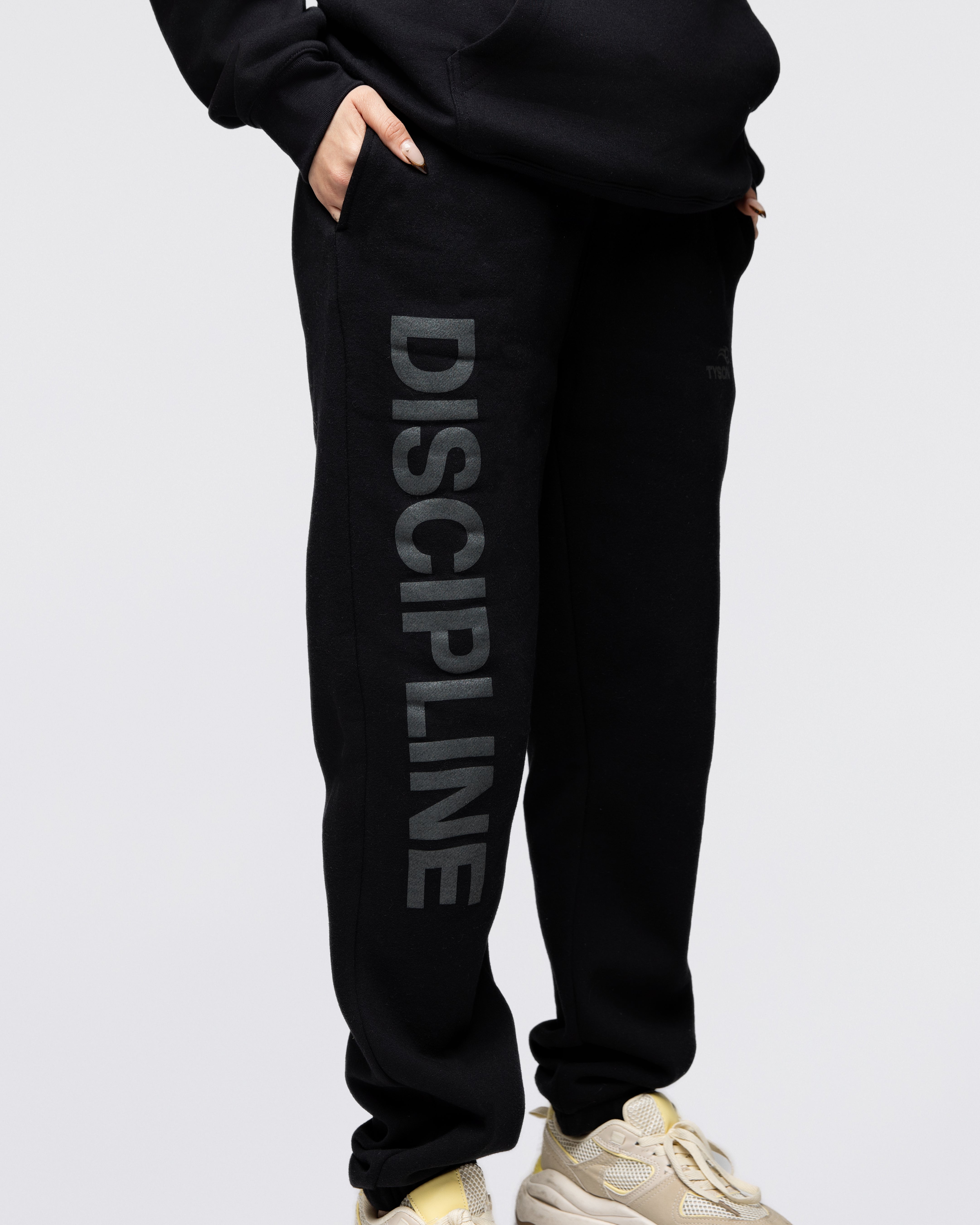 Black sweatpants featuring the large text "Discipline" running down the right leg. The Tyson Pro logo is featured on the left leg pocket area.