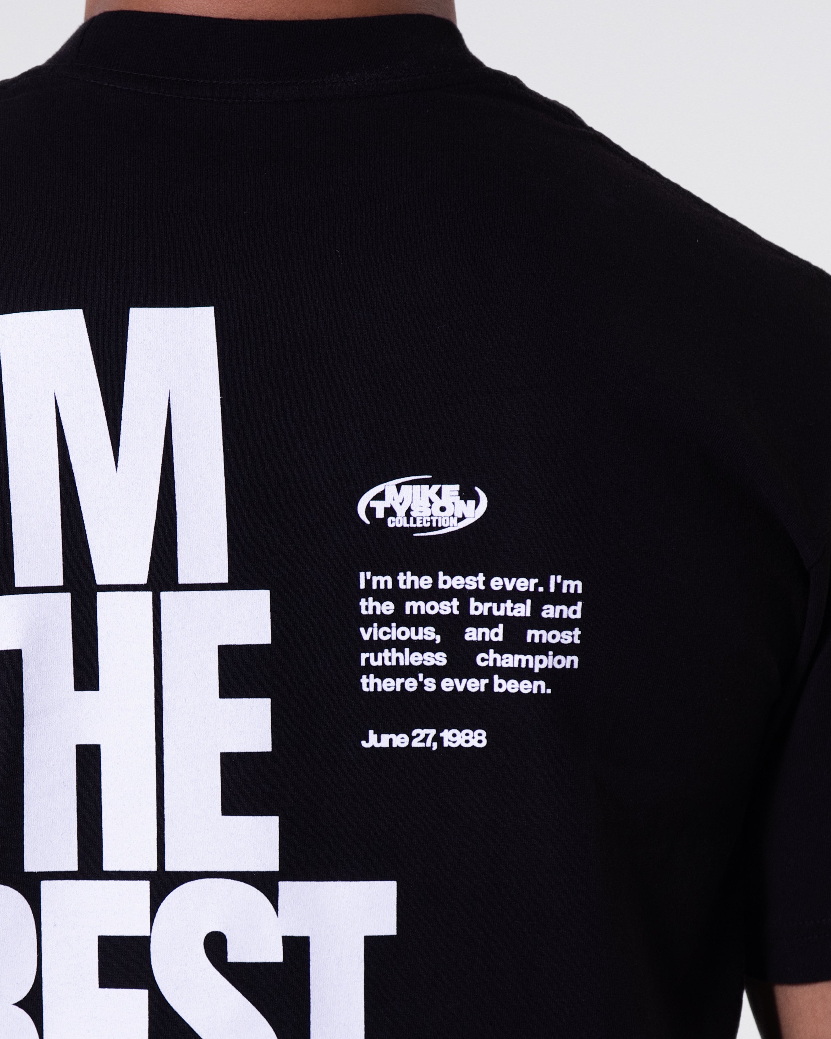 Black T-shirt. The back largely features the Mike Tyson quote "I'm the Best Ever" with the belt dates running down the left. In the upper right, the quote continues in smaller writing: "I'm the Best Ever. I'm the Most Brutal and Vicious, and Most Ruthless Champion There's Ever Been."