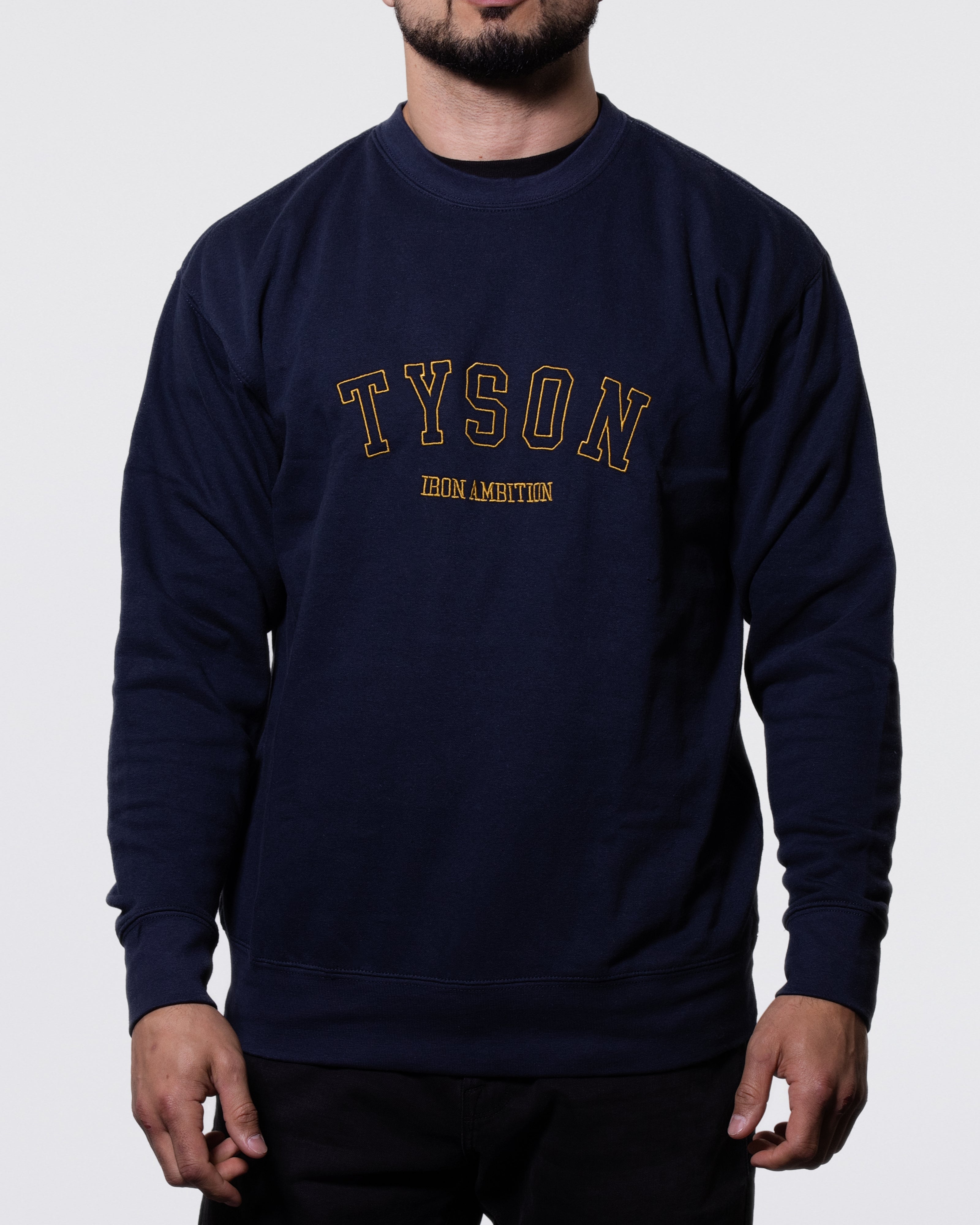 Navy long sleeve collegiate crewneck sweatshirt. Tyson Iron Ambition is embroidered in gold on the front.