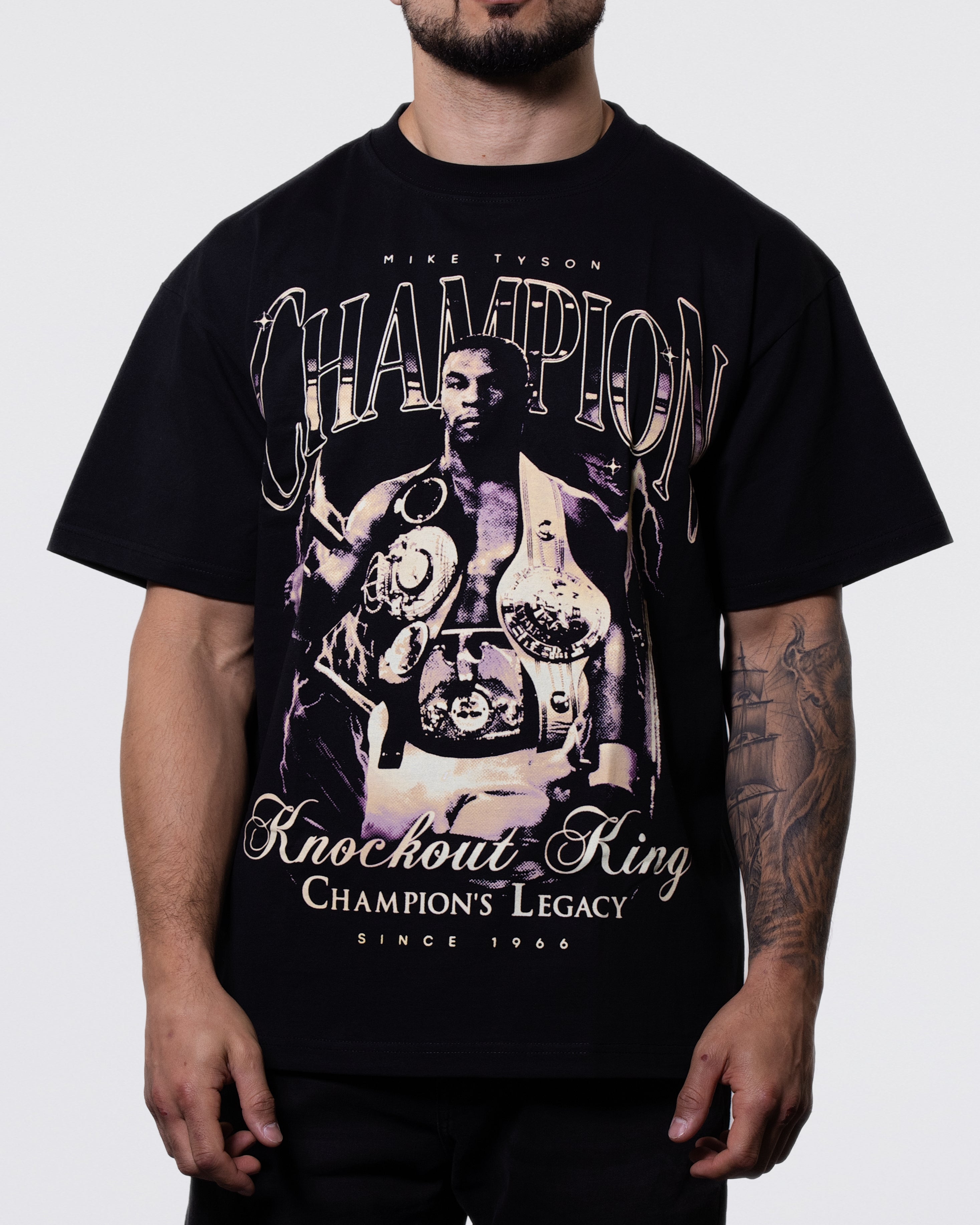 Black T-shirt. The front of the shirt displays a victorious Mike adorning himself with his belts, while the back displays him alongside his 44 incredible knockouts throughout his boxing career to date.