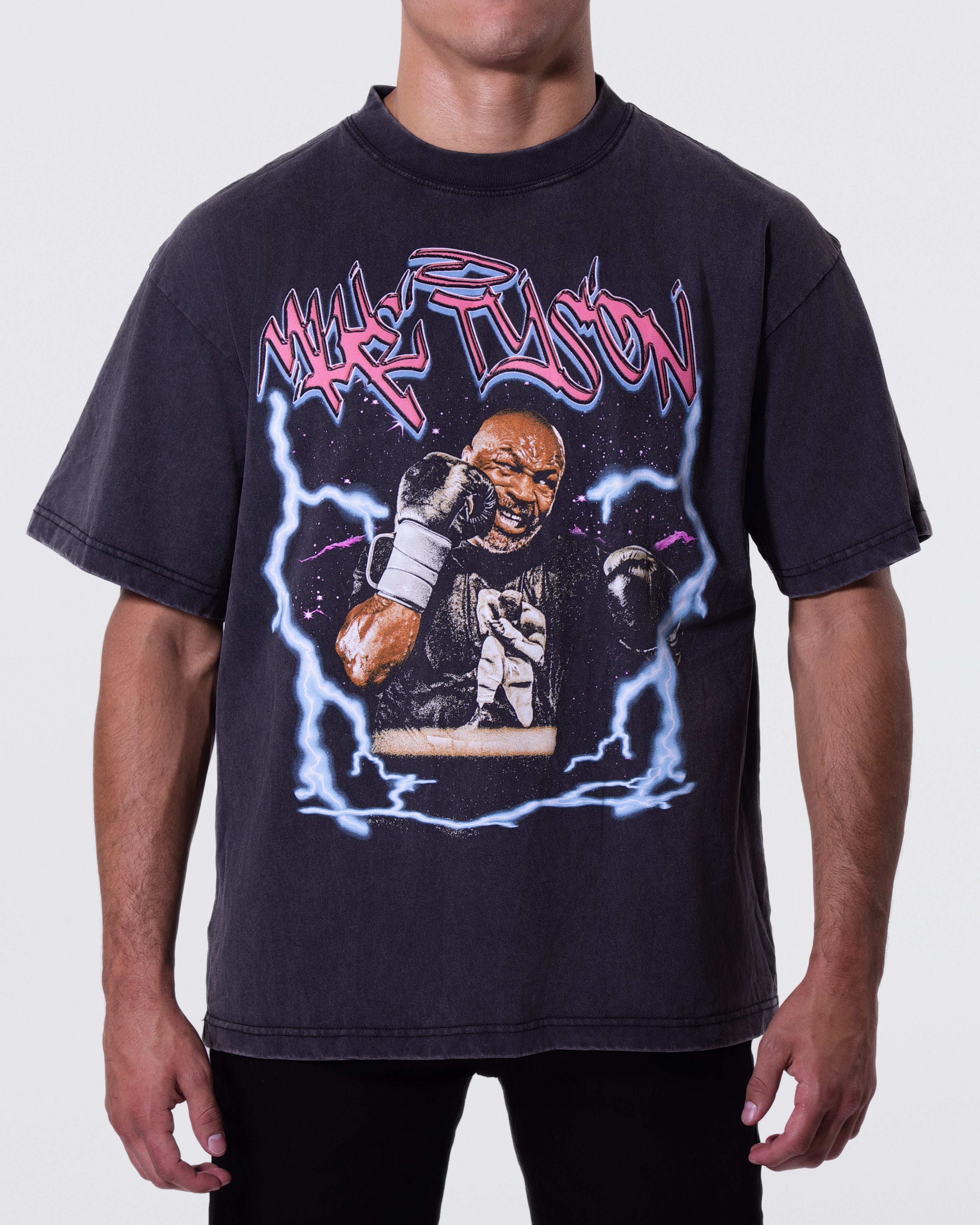 Black, Snow Wash T-shirt with an image of Mike Tyson throwing a punch, surrounded by blue lightning designs. "Mike Tyson" written in graffiti-like text above the image. 