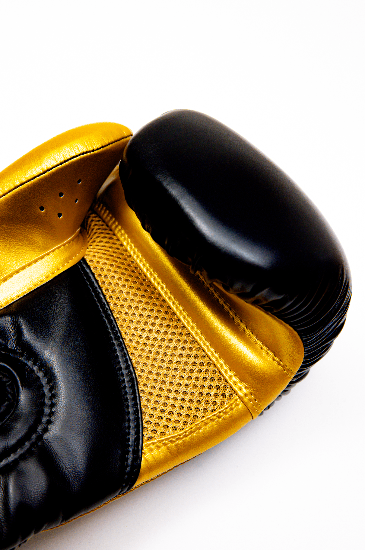 Black boxing gloves with gold accents. The Tyson half tribal logo is featured on the back of the gloves and the Tyson Pro logo is on the wrist strap. The palm area has mesh.