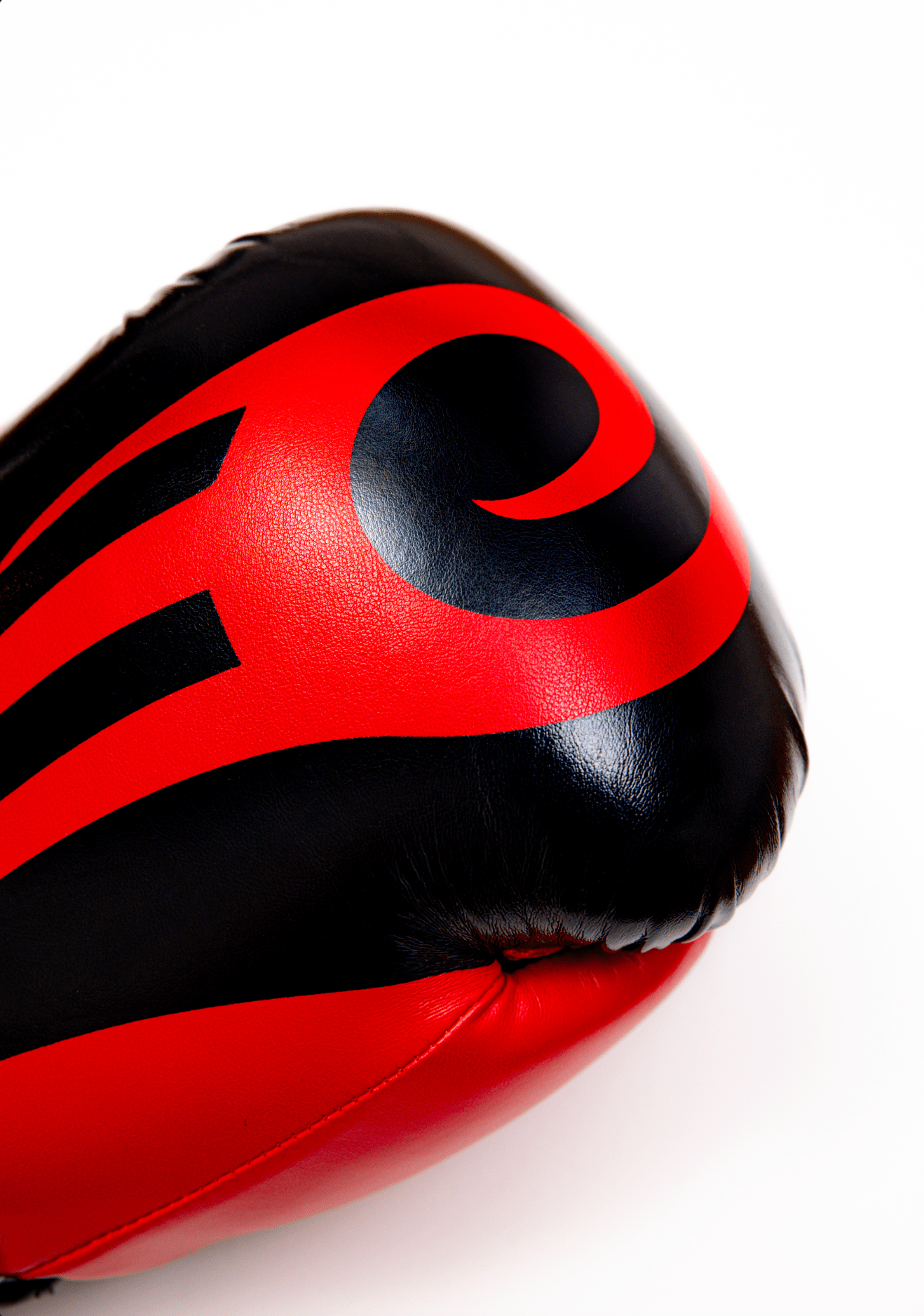 Black boxing gloves with red accents. The Tyson half tribal logo is featured on the back of the gloves and the Tyson Pro logo is on the wrist strap. The palm area has mesh.