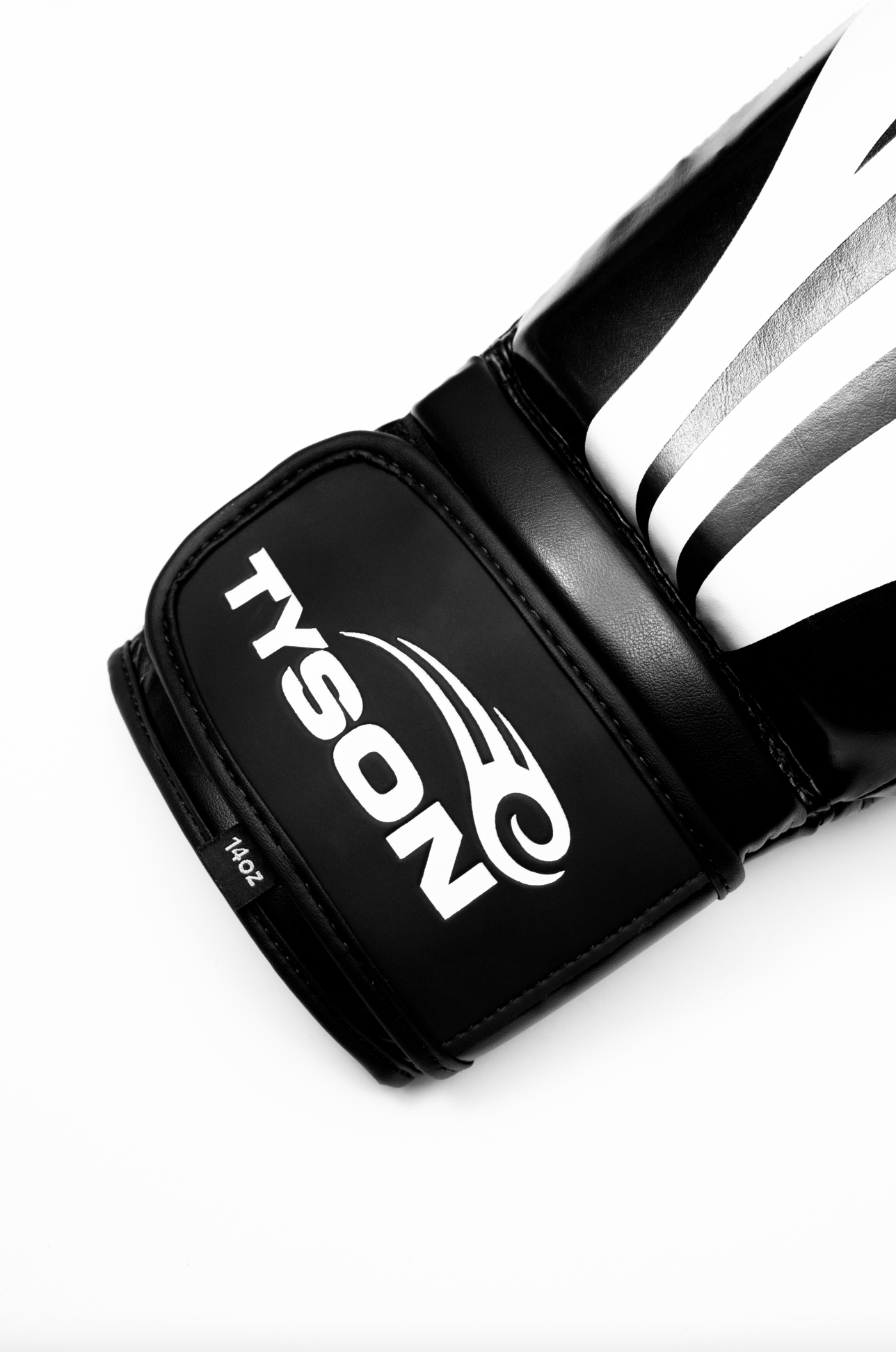 Black boxing gloves with white accents. The Tyson half tribal logo is featured on the back of the gloves and the Tyson Pro logo is on the wrist strap. The palm area has mesh.