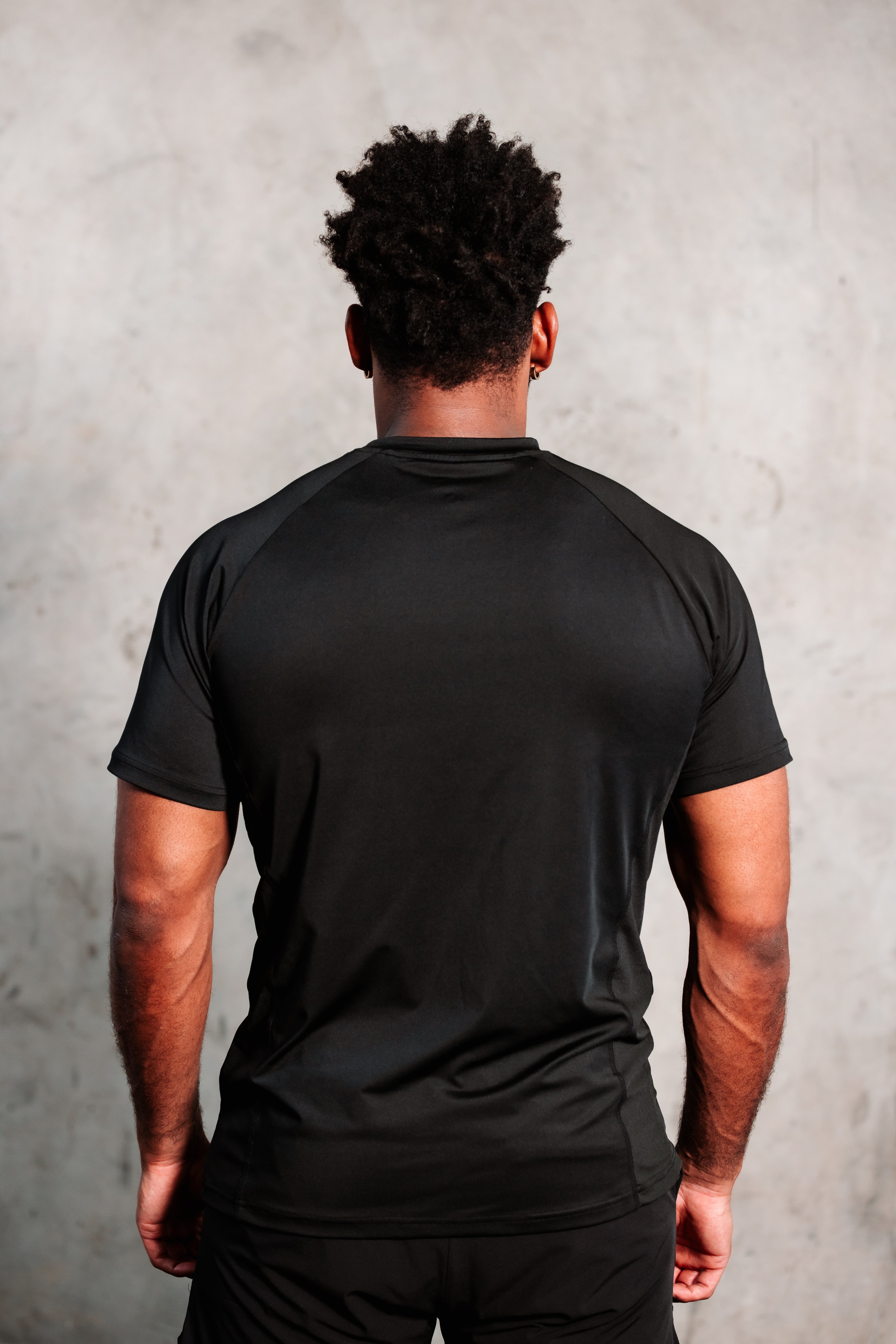 Model showing the back of the Tyson Pro Performance Shirt.