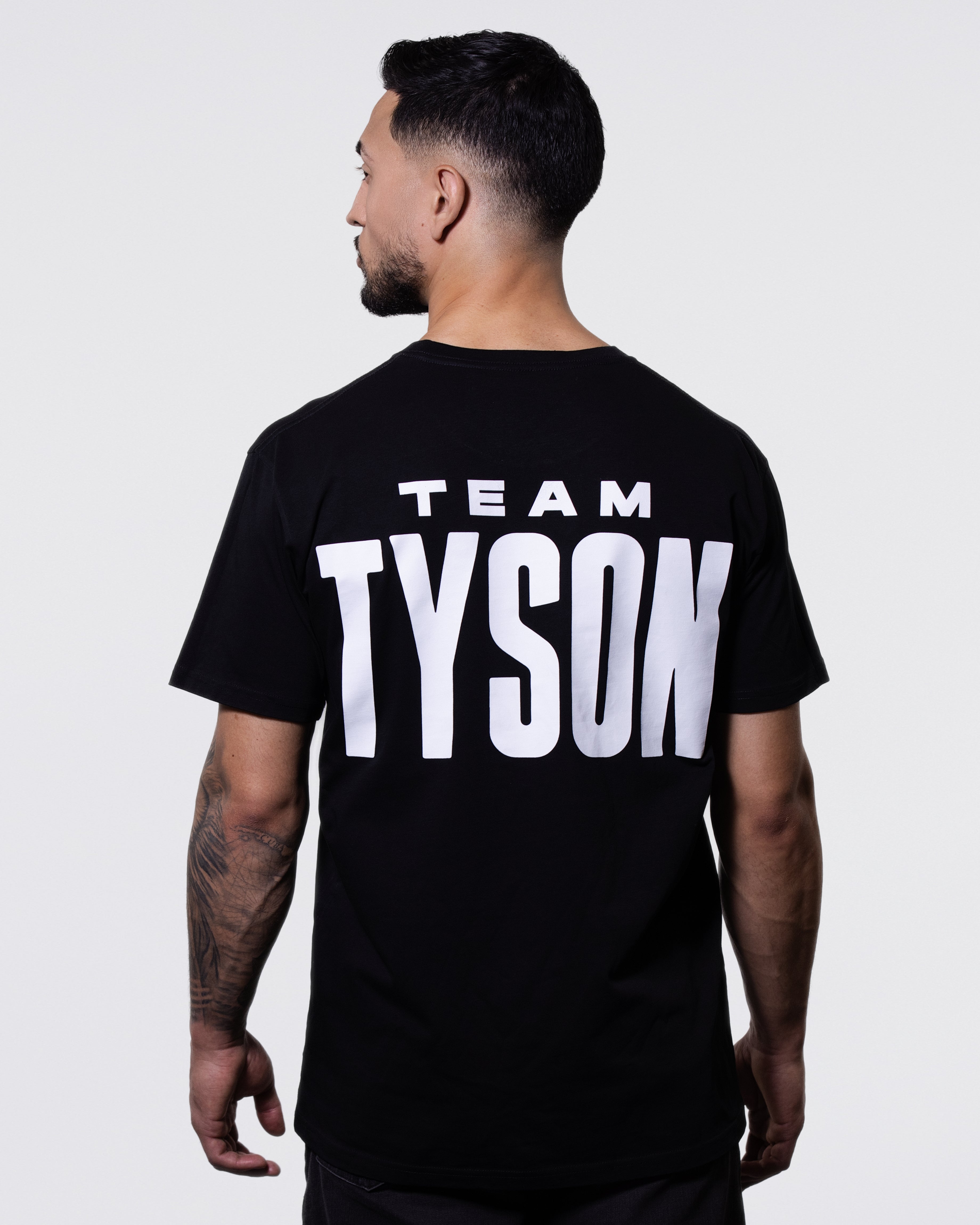 Black T-shirt. The back features white text that says "Team Tyson" and the front has the Tyson Pro logo small on the left chest area.